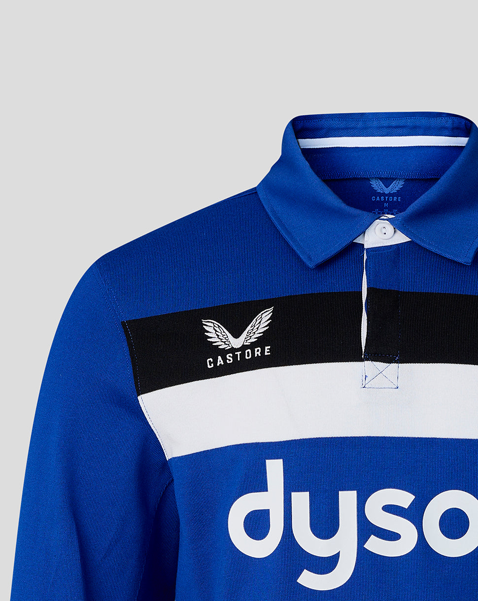 Blue polo shirt with Castore and Dyson logos on a gray background