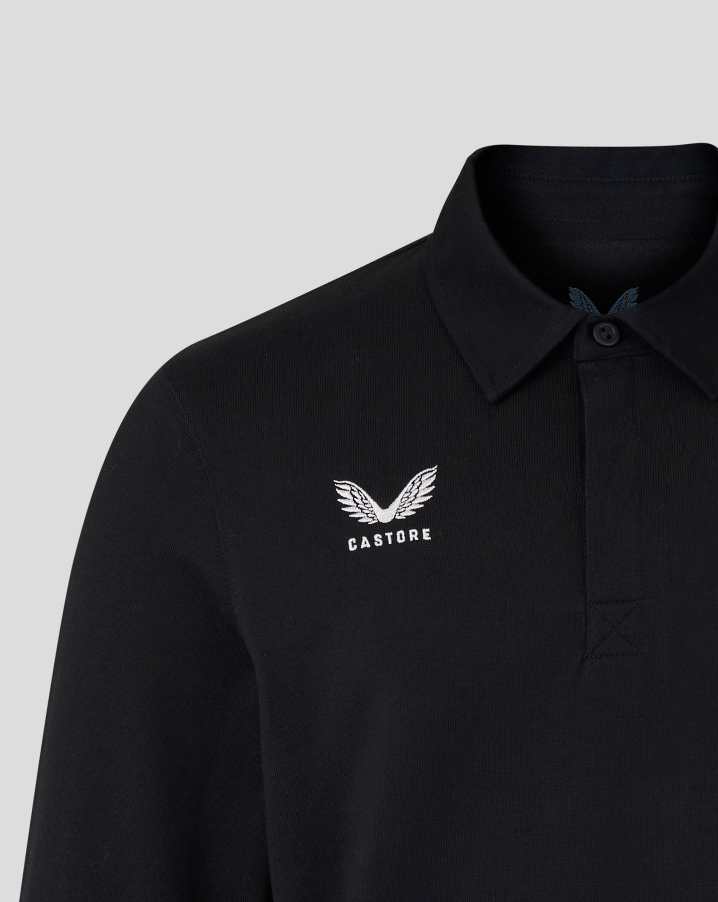 Black polo shirt with white logo on a light gray background