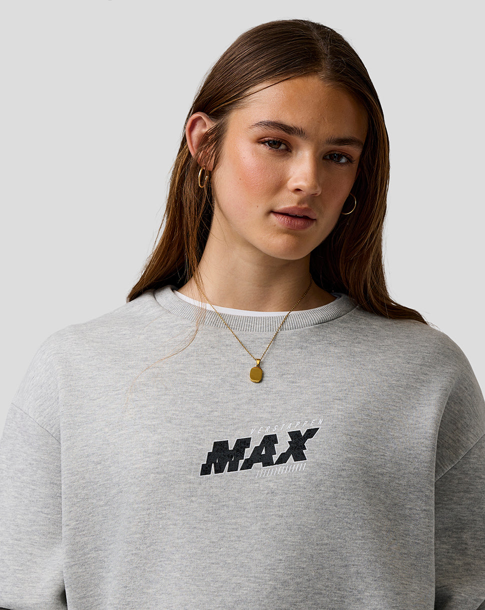 Person wearing a gray sweatshirt with 'MAX' print on a plain background