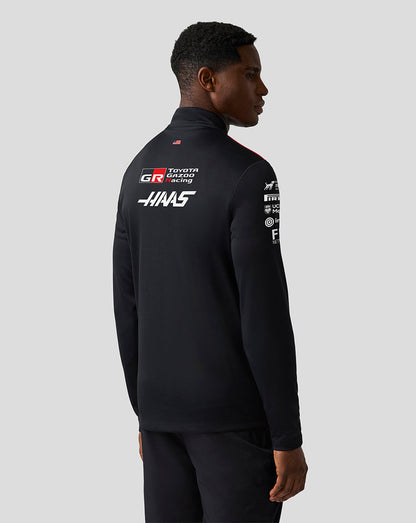 Person wearing a black jacket with Toyota Gazoo Racing logos on the back against a white background