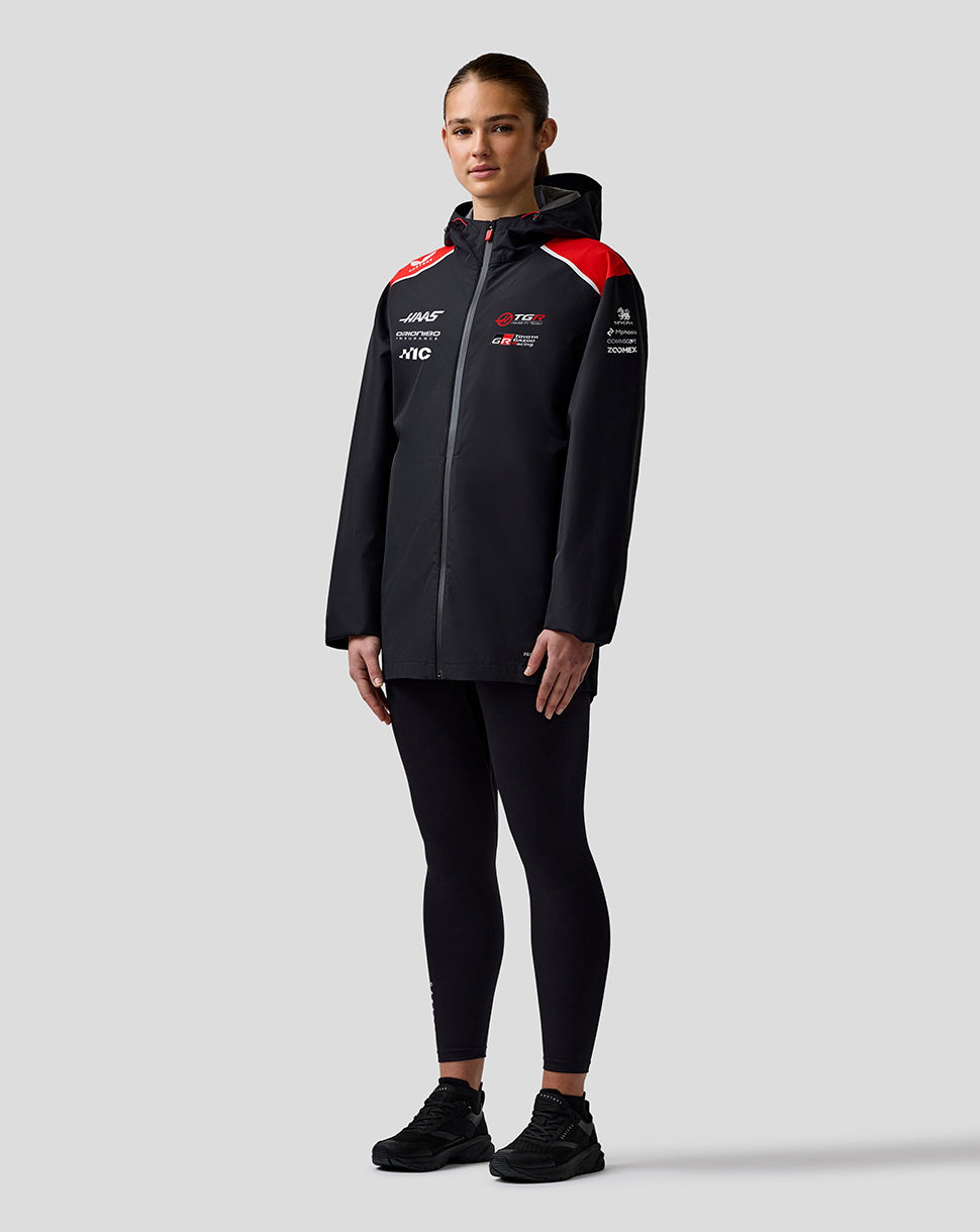 Person wearing a black tracksuit with red accents on a white background