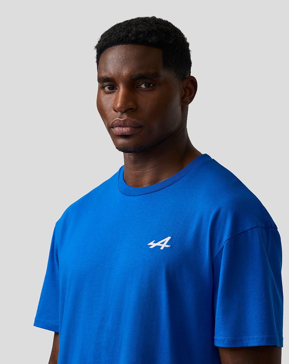 Close up of a male model wearing lapis blue unisex relaxed fit T shirt with embroidered A logo on the left chest