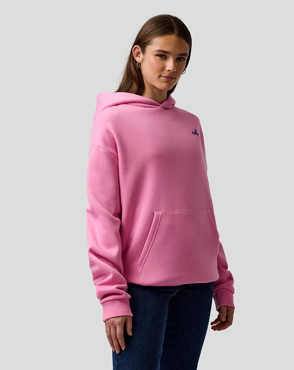Female model in a pink relaxed fit hoodie with hood and front pocket.