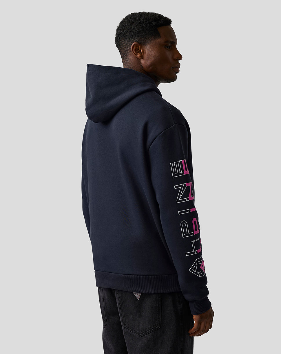 Side profile of a model wearing the navy BWT Alpine hoodie, right sleeve features vertical white and pink graphic text.