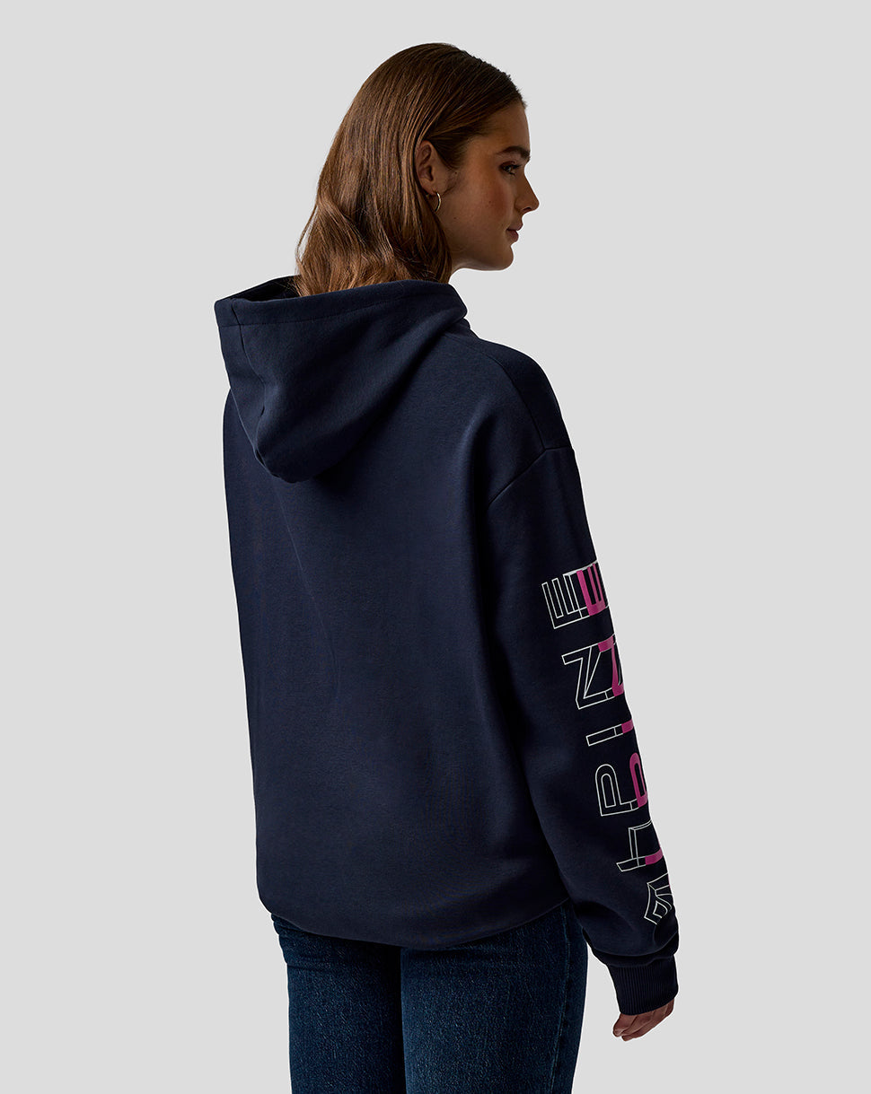 Back view of a model in a navy BWT Alpine hoodie with hood up and bold sleeve graphics visible.
