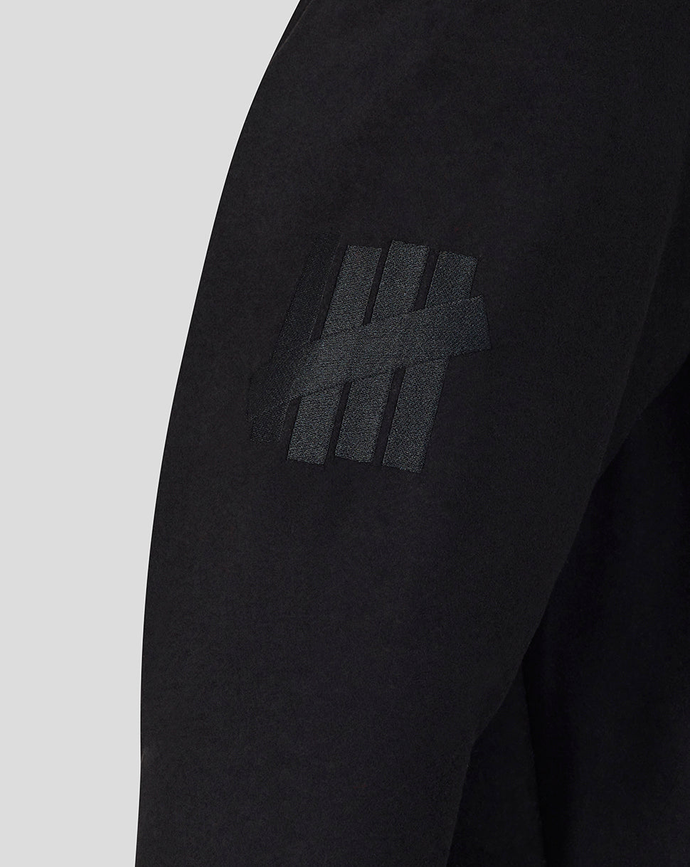 Black long-sleeve shirt with a logo on the sleeve against a light gray background