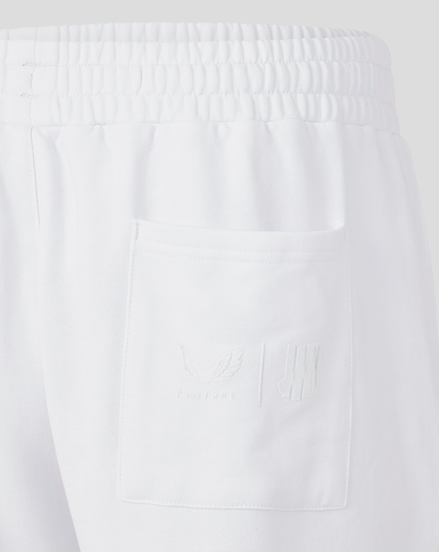 Close-up of a textured white fabric with a pocket on a light gray background