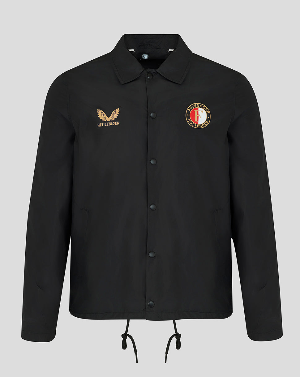 A black long-sleeve button-up jacket with a collar, featuring a gold embroidered winged logo and 'HET LAKEN' text on the right chest, and a circular red, white, and gold crest on the left chest. The jacket is displayed on a neutral light gray background.
