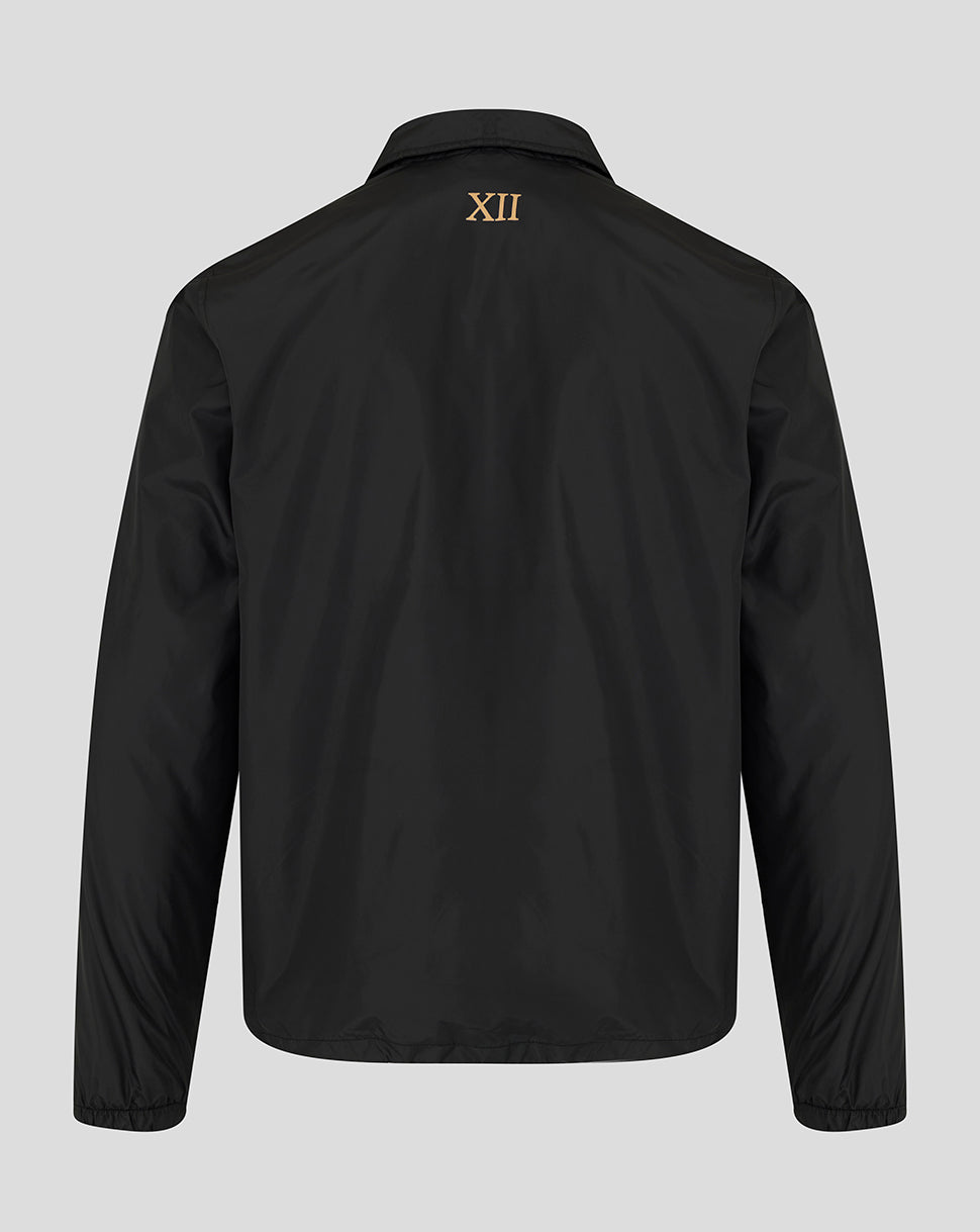 A black long-sleeve jacket shown from the back, featuring a small gold Roman numeral XII printed on the upper back, set against a solid light gray background.