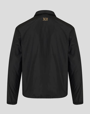 A black long-sleeve jacket shown from the back, featuring a small gold Roman numeral XII printed on the upper back, set against a solid light gray background.