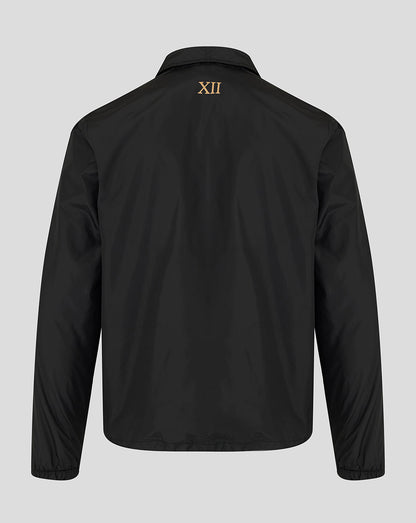 A black long-sleeve jacket shown from the back, featuring a small gold Roman numeral XII printed on the upper back, set against a solid light gray background.