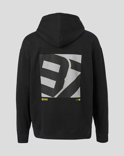 Black pullover hoodie shown from the back, featuring a large square graphic print with a stylized white and gray letterform and small yellow accents near the bottom of the graphic, on a light gray background.