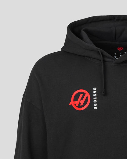 A close-up of a black pullover hoodie featuring a red circular logo with a stylized 'H' on the left chest and the word 'CASTORE' printed vertically in white next to it, set against a light gray background.