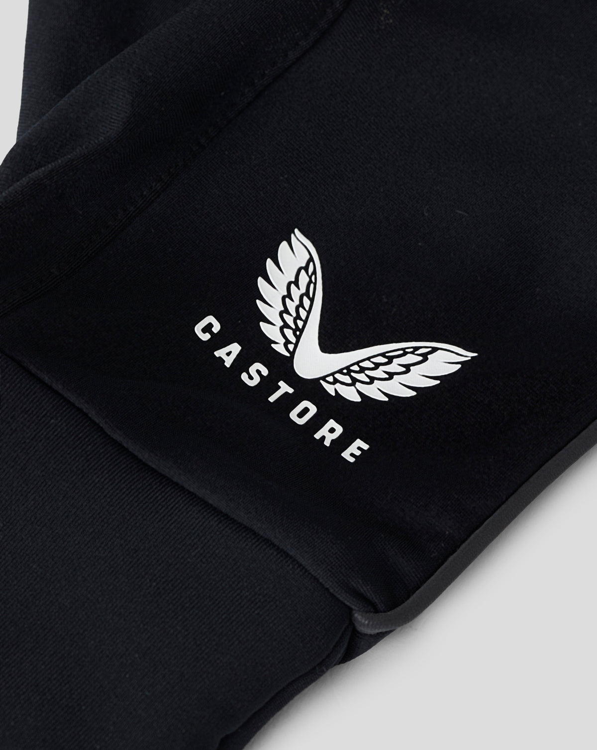 Close-up of white Castore logo on black fabric glove