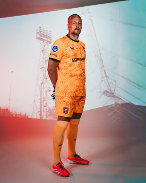 FC Twente goalkeeper in orange 26/27 jersey with black collar and club crest on chest