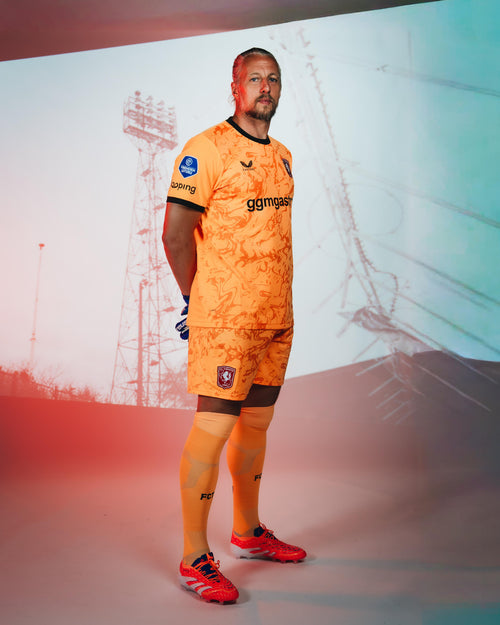 FC Twente goalkeeper in orange 26/27 jersey with black collar and club crest on chest