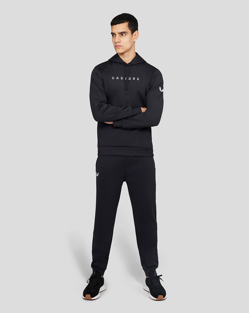 Male model in a full Onyx Flex Jogger set with a CASTORE hoodie bearing branding on the chest and a laurel logo on the sleeve.