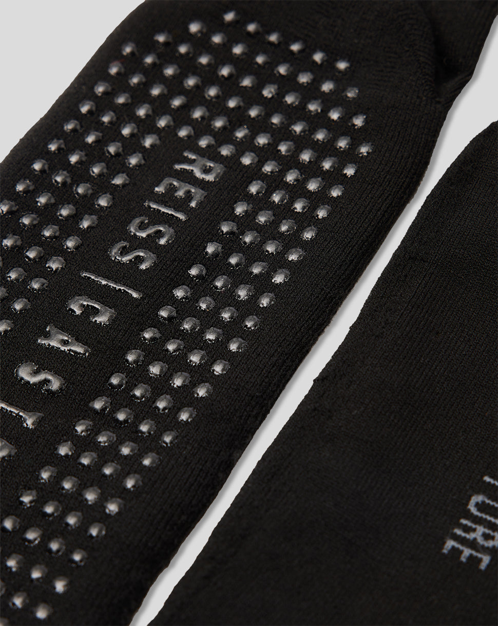 Black Robyn Yoga socks with dotted grip on the sole and REISS CASTORE branding.