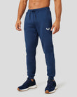 Peacoat Flex Jogger in deep blue with white wing logo at the thigh, shown with navy sneakers