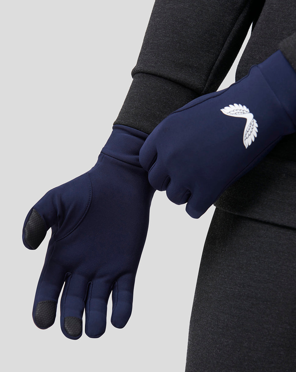 Close up of navy performance gloves with white wing logo and grip pads on the fingertips.
