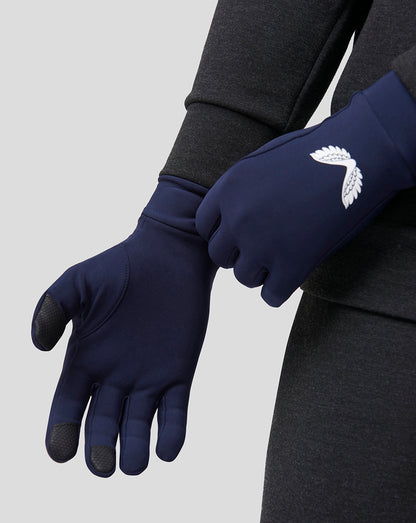 Close up of navy performance gloves with white wing logo and grip pads on the fingertips.