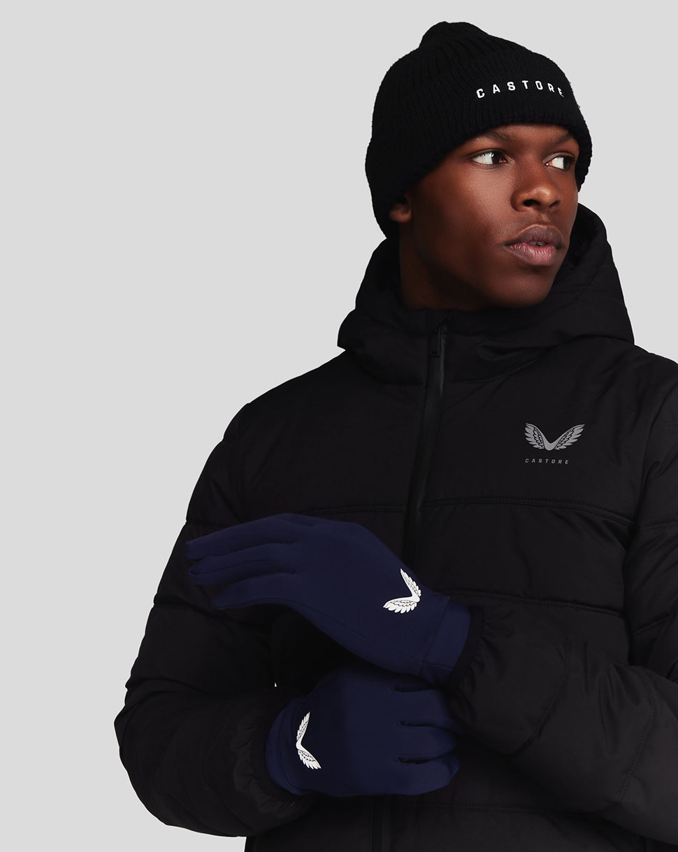 Model wearing navy Peacoat Performance Gloves with white wing logo and a black jacket.
