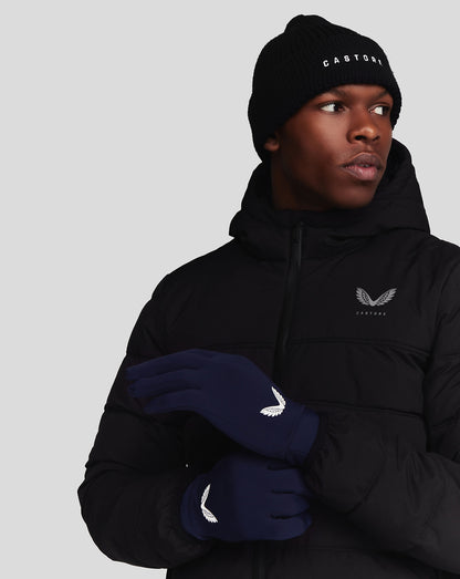 Model wearing navy Peacoat Performance Gloves with white wing logo and a black jacket.